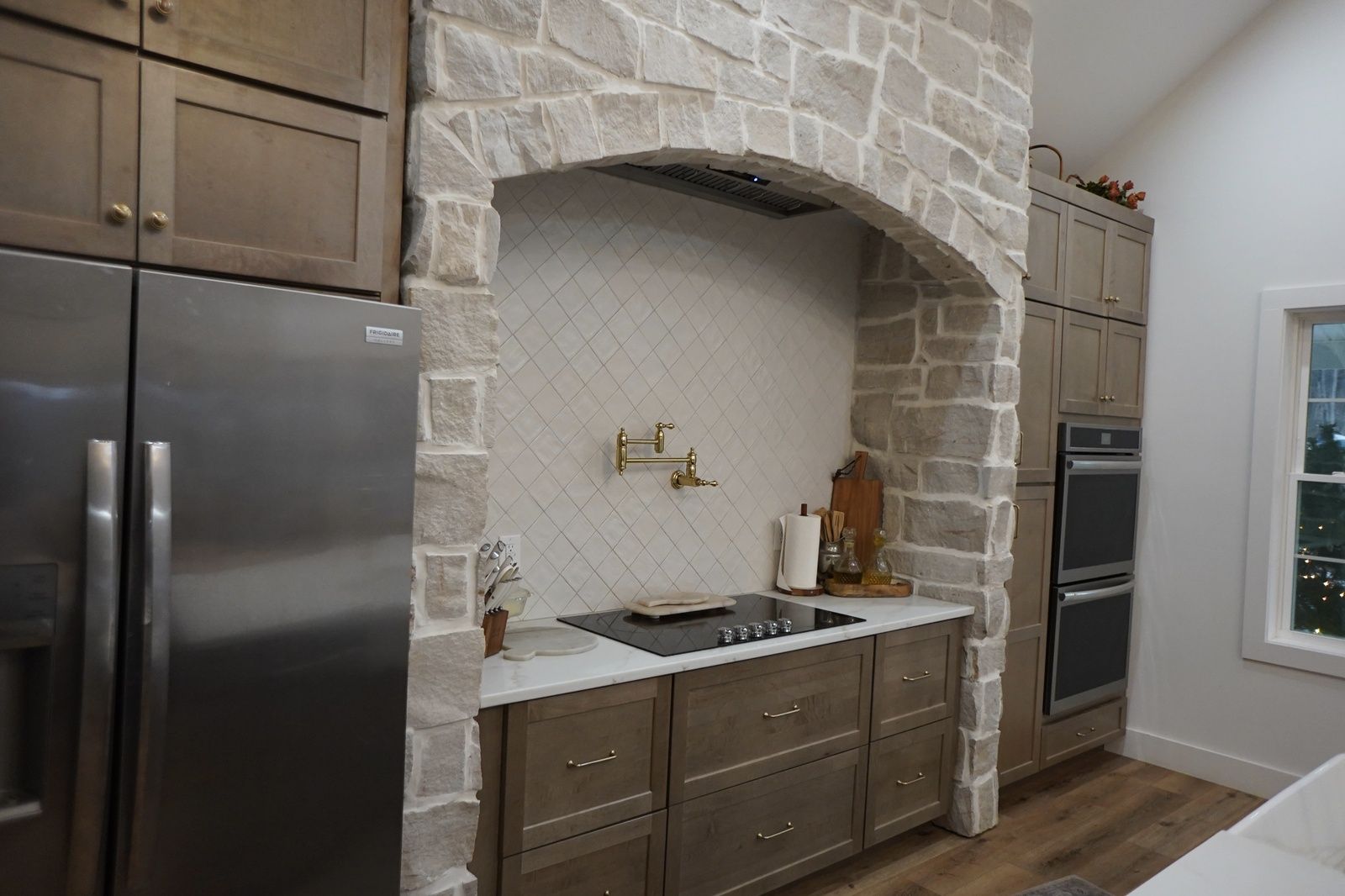 modern kitchen with stone arch and gold faucet details va