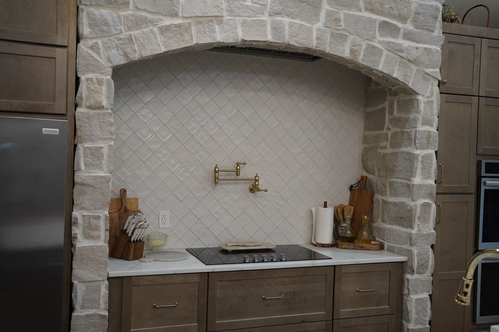 stone arch kitchen with gold faucets and cabinets va